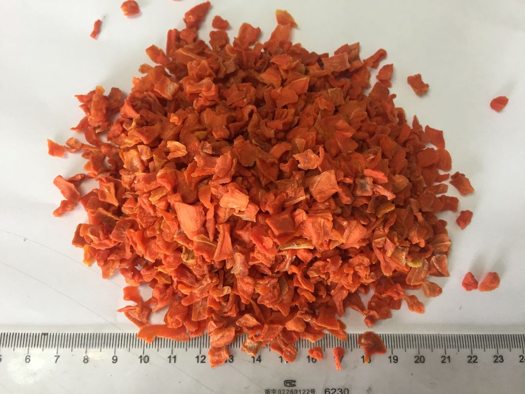 La carota secca rosso luminoso scheggia delizioso tipico della parte della radice con l'alto zucchero
